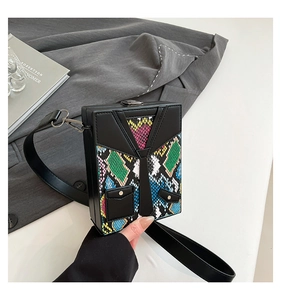 Close-up of black box crossbody bag featuring colorful snake pattern and tie detail