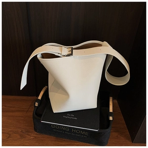 Detailansicht der cremefarbenen Eimertasche aus Kieselleder mit silbernen Schnallen