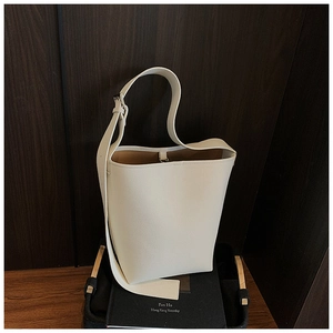 Nahaufnahme der minimalistischen cremeweißen Beuteltasche aus Leder mit braunem Futter