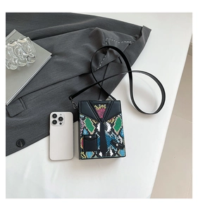 Detail showing mini shoulder bag in suit and tie design with colorful snakeskin pattern