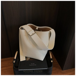 Detail der weißen Beuteltasche mit Kieselleder-Textur und verstellbarem breitem Gurt