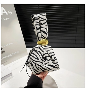 Detailed shot of zebra pattern fabric handbag with premium gold metal clasp design