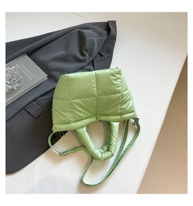 Close-up of light green quilted puffer tote bag with large square stitching and glossy finish