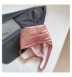 Macro shot of pink metallic quilted fabric and wide adjustable strap on a shoulder bag