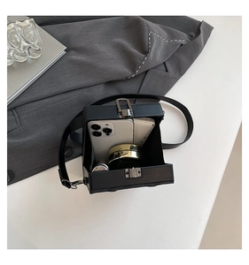 Detail view of the black box crossbody bag interior showing phone and daily essentials
