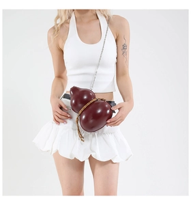 Detail of glossy wine red gourd crossbody bag with woven cord and silver chain strap