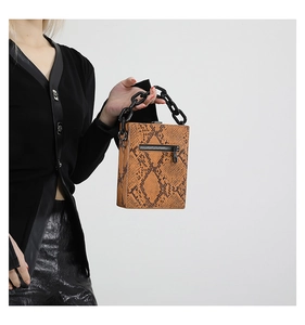 Detail view of the brown python pattern bag featuring a chunky black chain and zipper back pocket