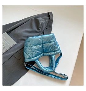 Detail of blue quilted puffer tote bag with metallic sheen and adjustable strap