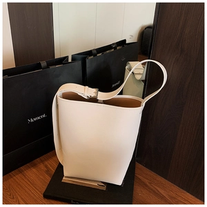 Detailansicht der cremeweißen Eimer-Tasche aus Lychee-Leder mit silberner Metallschnalle