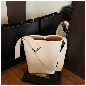 Detail der weißen Beuteltasche mit Litchi-Maserung und breitem Schultergurt