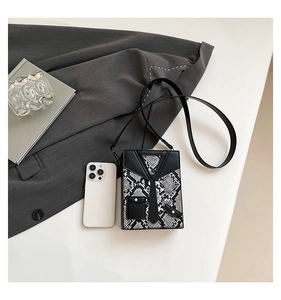 Detail view of snakeskin textured crossbody bag with creative formal suit design