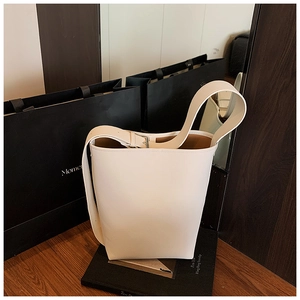 Nahaufnahme der weißen Leder-Beuteltasche mit breitem Schultergurt und Metallschnalle