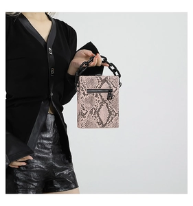 Detailed close-up of pink snake skin texture small square bag with bold black chain handle
