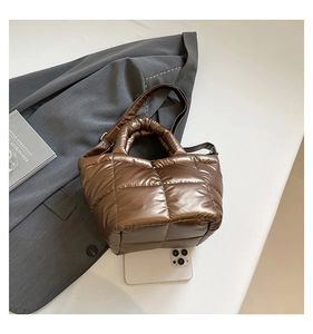 Detail of quilted metallic coffee tote bag with padded handles and adjustable strap
