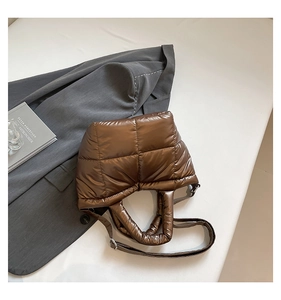 Close-up of a glossy quilted down shoulder bag in dark brown with adjustable strap