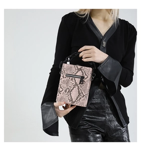 Detailed close-up of pink snakeskin pattern bag with black acrylic chain handle