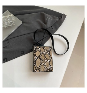 Macro shot of retro hard shell box bag featuring luxury snake print texture and strap