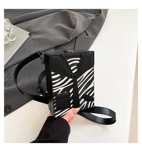 Detail of zebra pattern crossbody box bag with tuxedo style tie and metal clasp design