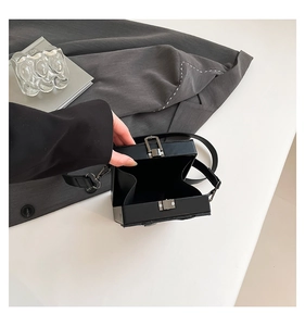 Detail view of black square box crossbody bag showing interior structure and silver clasp
