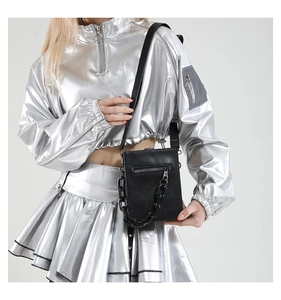 Detail view of black crocodile pattern crossbody bag with oversized resin chain decoration