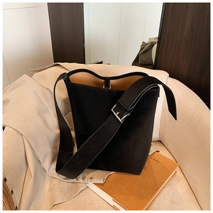 Detail einer schwarzen Lederbeuteltasche mit silberner Schnalle auf einem Stuhl