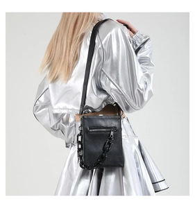 Detail of black snake pattern crossbody bag with textured leather and bold chain strap