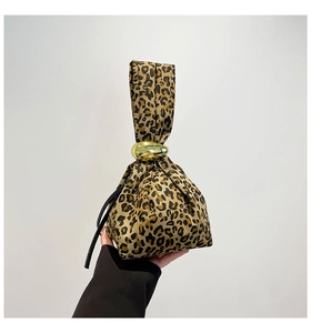 Detailed view of the leopard print canvas handbag with a round golden metal buckle