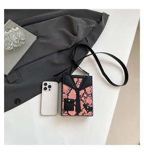 Macro view of a snake-pattern box bag with creative tuxedo suit design elements