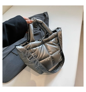 Detail of silver metallic quilted tote bag with puffer padding and adjustable strap