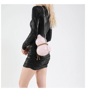 Detail of pink gourd-shaped crossbody bag with silver chain strap and woven rope
