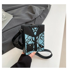 Close-up of hard shell crossbody bag with suit design and blue snakeskin texture