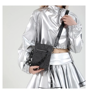 Detail of snake pattern crossbody bag with chunky chain strap on fashion model
