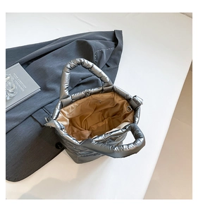 Detail of silver quilted tote bag interior with zipper pocket and magnetic snap closure