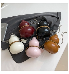 Flat lay of mini gourd-shaped crossbody bags in five colors with silver metal chains