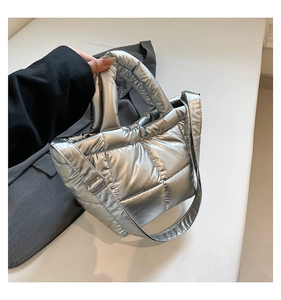 Detail of silver quilted padded tote bag featuring metallic finish and soft padded handles