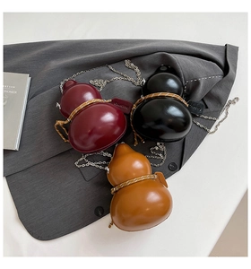 Three creative gourd-shaped crossbody bags in burgundy, black and yellow with chain straps