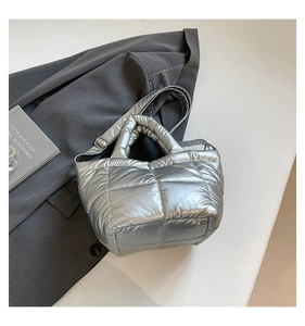 Close-up of quilted silver down tote bag with metallic finish and adjustable strap