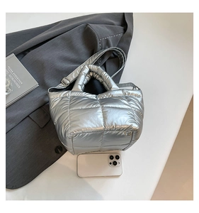 Detail of silver quilted tote bag with padded handles and adjustable shoulder strap