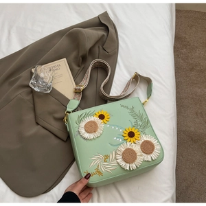 Detailed embroidery of sunflower and daisy on a mint green crossbody shoulder bag