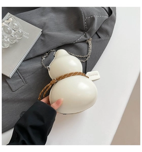Detail shot of a white gourd-shaped bag with brown woven rope and silver chain strap
