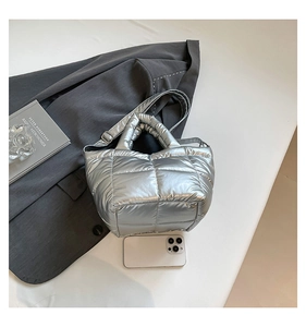 Detailed view of silver quilted tote bag showing padded texture and adjustable strap