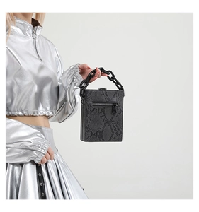 Detail of the grey python texture crossbody bag with bold black chain and back zipper