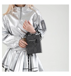 Detail of dark grey snakeskin print box bag with bold black plastic chain handle