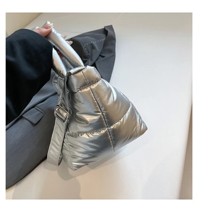 Detailed close-up of quilted silver puffer tote bag with metallic finish and adjustable strap