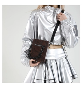 Detail of dark brown faux-snakeskin crossbody bag with decorative black chunky chain