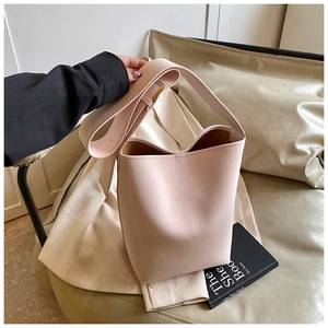 Detailansicht der beigefarbenen Eimer-Tasche aus strukturiertem Leder mit breitem Gurt