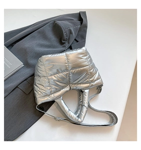 Detail of silver metallic quilted tote bag with padded handle and slim shoulder strap