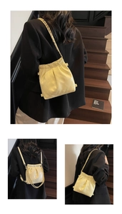 Detailed view of quilted bucket bag with gold chain strap and drawstring closure