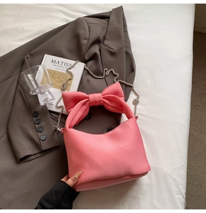Detailed view of the pink ribbon handbag featuring a metallic silver chain and satin finish