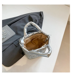 Detail view of silver quilted tote bag with metallic finish showing internal zipper pocket